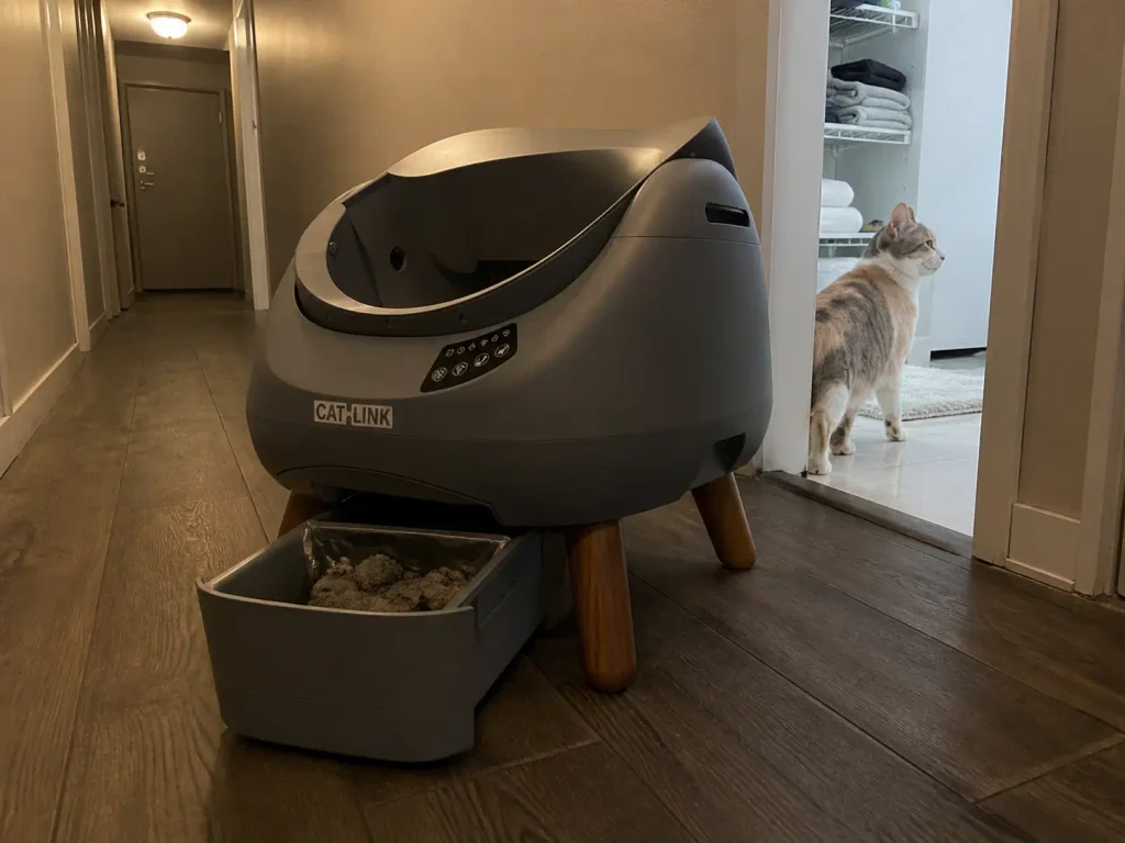 Full waste drawer of a large-capacity automatic litter box in an apartment hallway