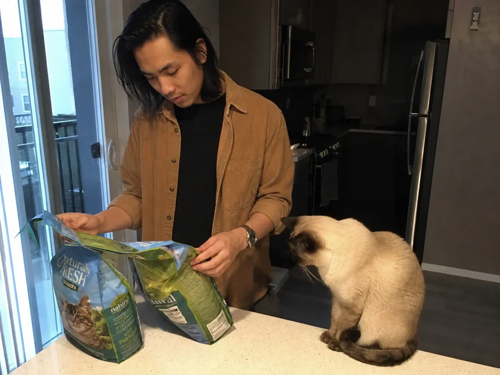 Two bags of cat litter side by side on a kitchen counter being compared before buying