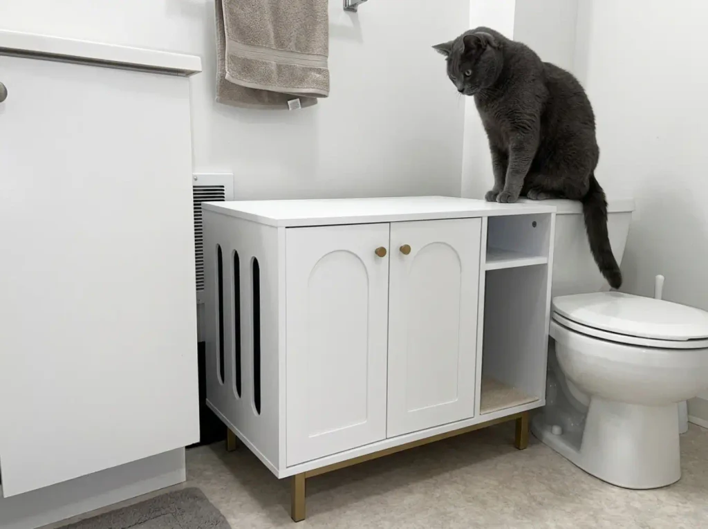 Hzuaneri litter box enclosure in a windowless bathroom corner showing its side ventilation openings
